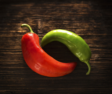red and green peppers on a wooden table の写真素材
