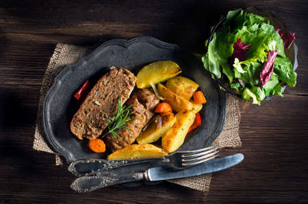 Roasted minced meat with potatoes and salad close upの写真素材