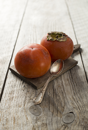 Persimmons - kaki on wooden table close upの写真素材