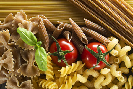 Raw pasta with basil and tomato overhead shootの写真素材