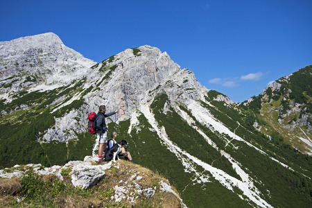 Hikers with backpacks enjoying view from top of a mountainの写真素材