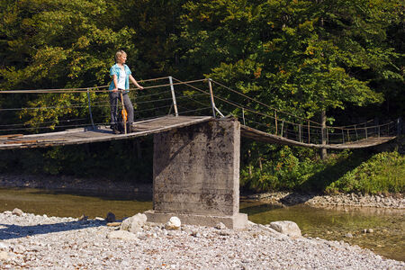 Young woman with backpack relaxing on a bridgeの写真素材