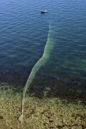 Fisherman lifting fishing net shoot from topの写真素材