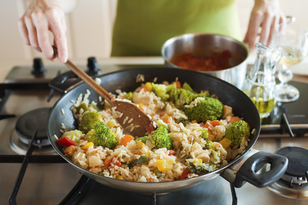 Woman cooking risotto on stove close up shootの写真素材