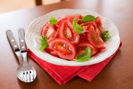fresh tomato slice with basil leaves in a bowlの写真素材