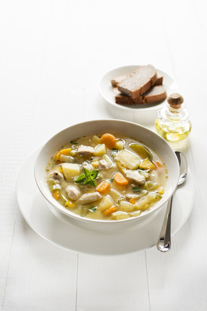 Fresh chicken stew with bread on white wooden background の写真素材