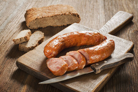 the sliced tasty sausage with bread on the wooden tableの写真素材