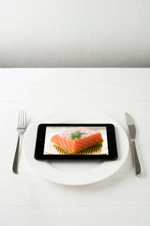 Tablet computer on a plate - mini photo on tablet is mine also.の写真素材