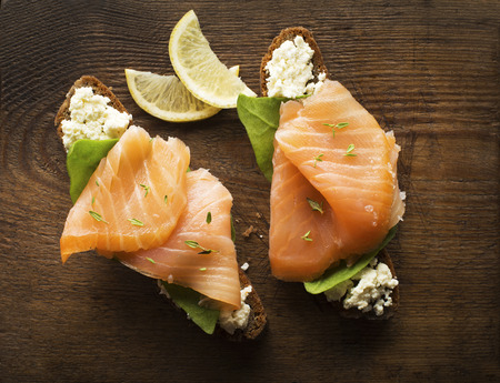 Slice of smoked salmon with bread on wooden backgroundの写真素材