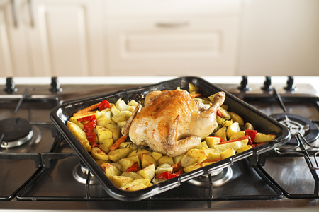 Roasted chicken with potatoes and vegetables- cooking in the ovenの写真素材