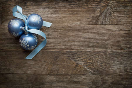 Christmas ornaments with silk ribbon on wooden backgroundの写真素材