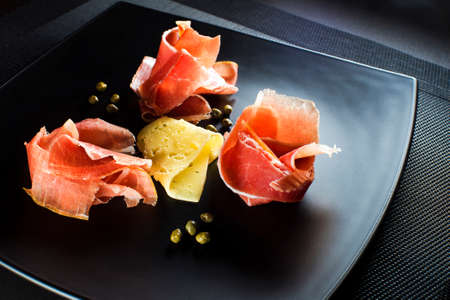 Fresh prosciutto with cheese and capers close upの写真素材