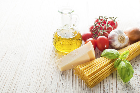 Spaghetti and tomatoes with parmesan cheese on a vintage wooden tableの写真素材