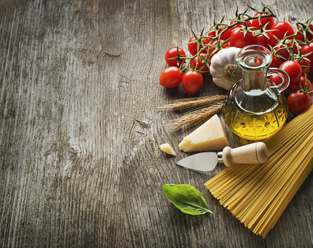Spaghetti and tomatoes with parmesan cheese on a vintage wooden tableの写真素材