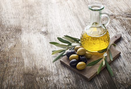 Olive oil and olive branch on the wooden tableの写真素材