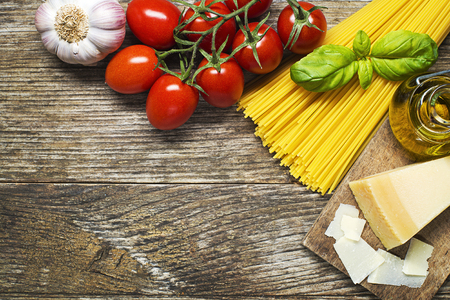 Spaghetti and tomatoes with parmesan cheese on wooden backgroundの写真素材