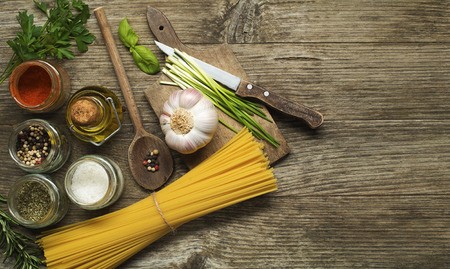 Pasta with spices and ingredients on old wooden tableの写真素材