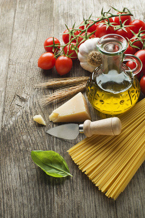 Spaghetti and tomatoes with parmesan cheese on a vintage wooden tableの写真素材