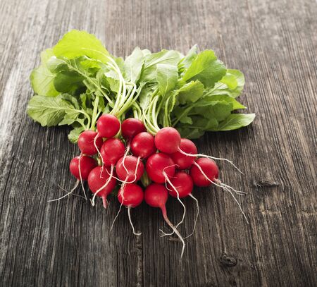 Bunch of fresh red radish on wooden tableの写真素材