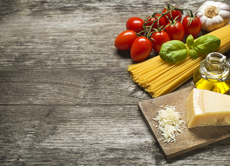 Spaghetti and tomatoes with parmesan cheese on a vintage wooden tableの写真素材