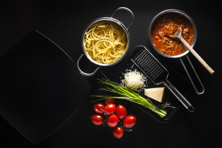 Fresh spaghetti with tomatoes sauce and parmesan on black backgroundの写真素材