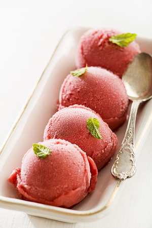 Fresh fruit ice cream balls in white plate.の写真素材