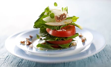 Fresh salad with tomatoes, spinach, fruits and nuts close up.の写真素材
