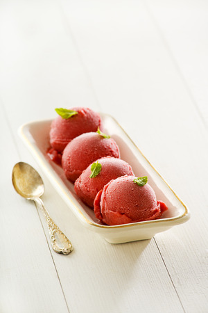 Fresh fruit ice cream balls in a white plate.の写真素材
