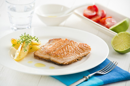 Grilled Salmon with roasted potatoes served on a plate.の写真素材