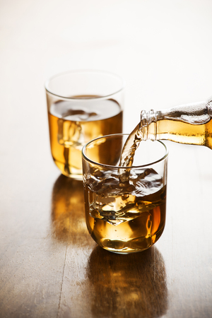 Pouring ice tea in glass with ice cubes.の写真素材