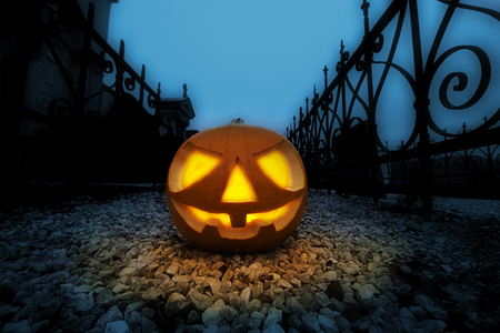 Scary halloween pumpkin in the dark graveyard at night.の写真素材