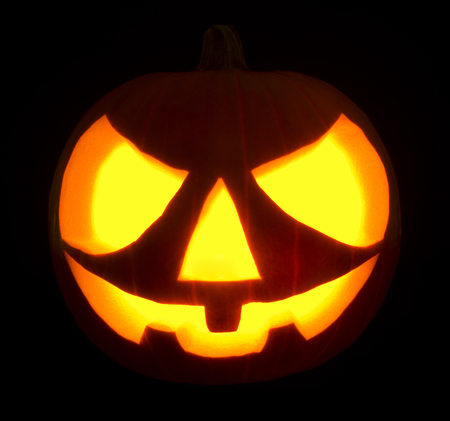 Halloween pumpkin jack-o-lantern on black dark background.の写真素材