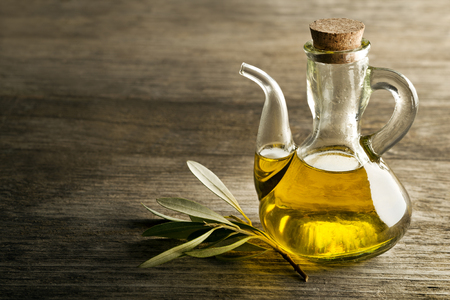 Olive oil and olive branch on the wooden table.の写真素材