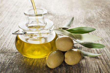 Virgin olive oil pouring in the bottle.の写真素材