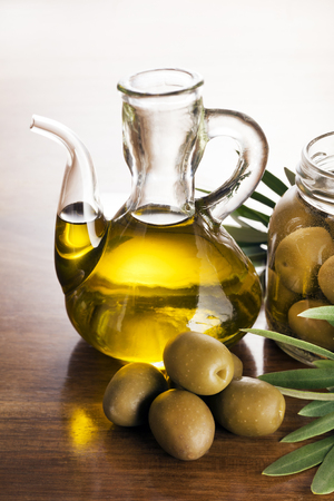 Olive oil and olive branch on the wooden table.の写真素材