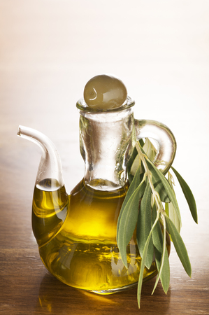 Olive oil and olive branch on the wooden table.の写真素材