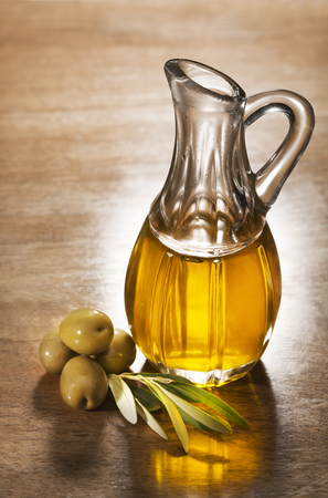 Olive oil and olive branch on the wooden table.の写真素材