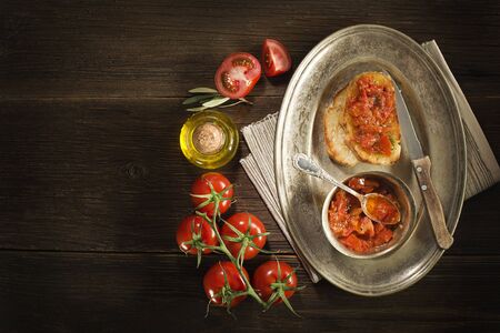 Toasted bread with tomato and olive oil on wooden background.の写真素材