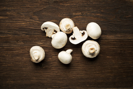 Fresh mushrooms champignons on a wooden background.の写真素材
