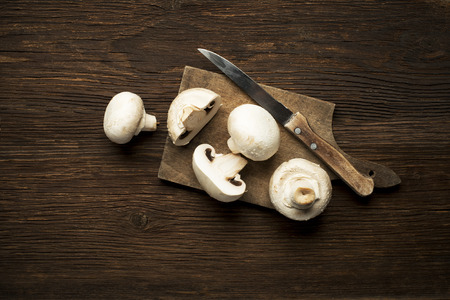 Fresh mushrooms champignons on a wooden background.の写真素材