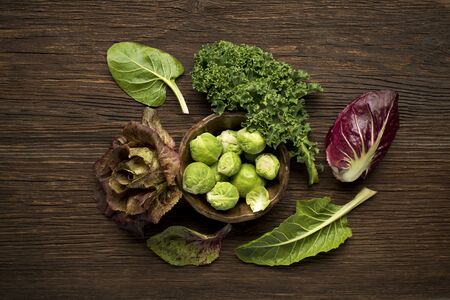 Brussels sprouts, kale, chard and radicchio vegetables on wooden backgroundの写真素材