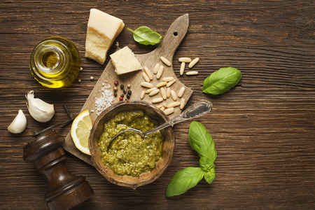 Fresh basil pesto ingredients on wooden background overhead shoot.の写真素材