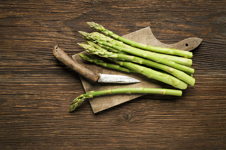 Fresh asparagus on wooden background overhead shoot.の写真素材