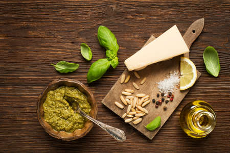 Fresh basil pesto with ingredients on wooden background.の写真素材