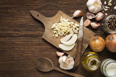 Ingredients with garlic cloves, onion and spices on wooden background.の写真素材