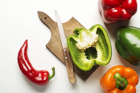 Red, green and orange bell peppers on white background.の写真素材