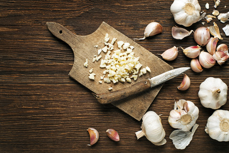 Garlic cloves and sliced garlic on vintage wooden background.の写真素材
