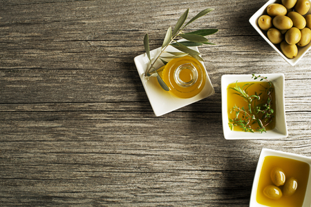 Olive oil with fresh herbs on wooden backgroundの写真素材