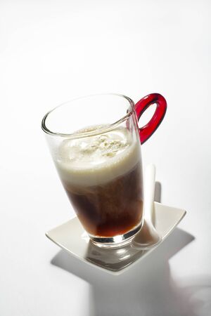 Fresh coffee in a tall glass with cream close upの写真素材