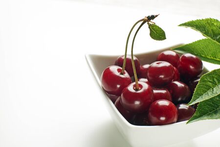 Fresh cherries in bowl on white background close upの写真素材